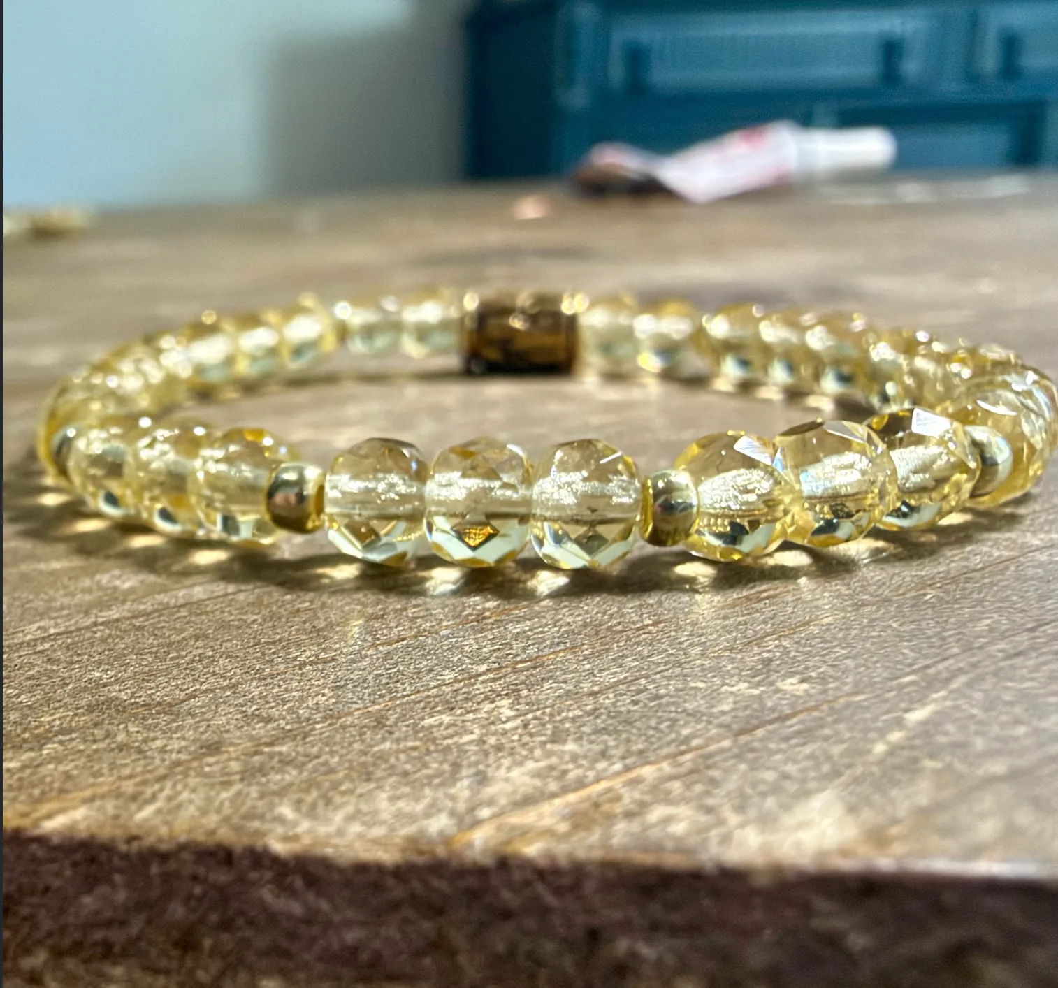 Faceted citrine beaded bracelet with brass spacer accents on elastic cord.