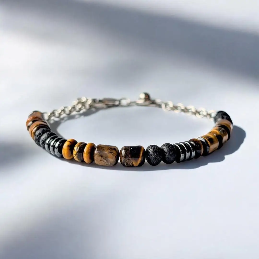Tiger's eye and black bead bracelet with silver chain clasp on white background.