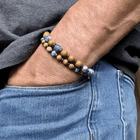 Man wearing a beaded bracelet with blue, gold, and silver stone beads.